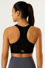 “Vista trasera de un top deportivo negro para mujer con tiras tipo nadador, resaltando ajuste y soporte para actividad física.”